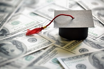 Graduation Cap on Top of Several Hundred Dollar Bills